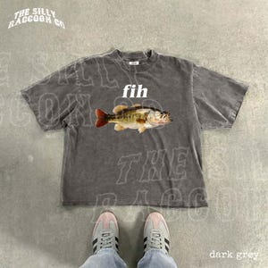 May include: Dark grey t-shirt with a graphic of a fish and the word "fih" in white. The shirt has the text "THE SILLY RACCOON CO" in a curved font at the top. The bottom right corner of the image has the text "dark grey".
