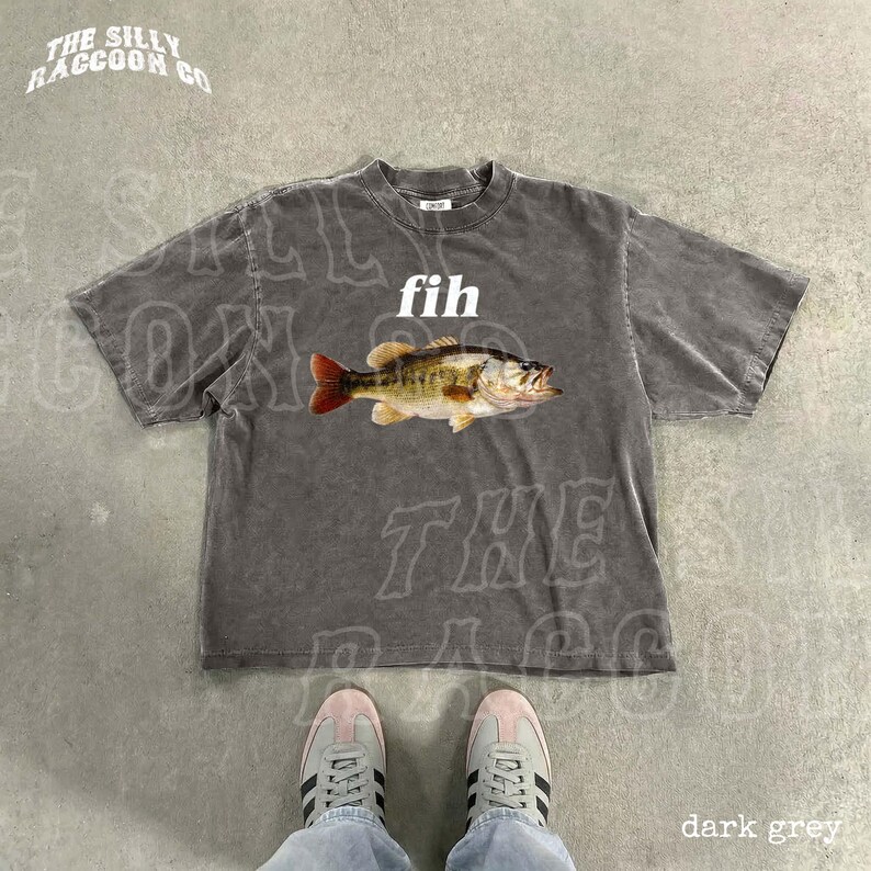May include: Dark grey t-shirt with a graphic of a fish and the word "fih" in white. The shirt has the text "THE SILLY RACCOON CO" in a curved font at the top. The bottom right corner of the image has the text "dark grey".