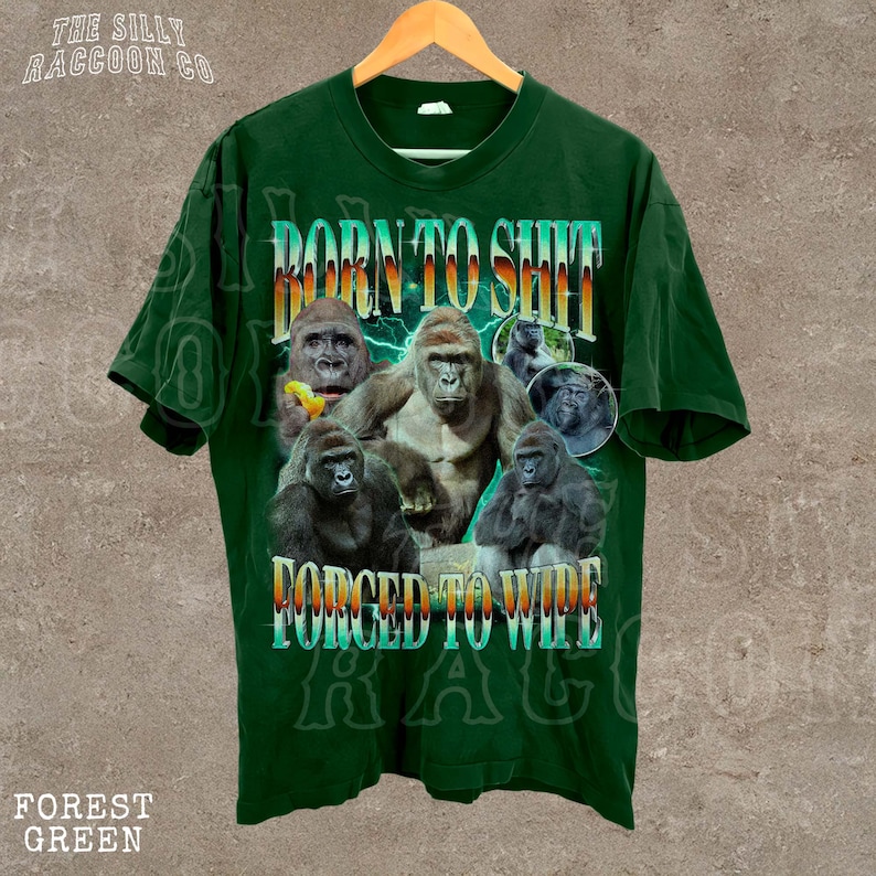 A green t-shirt with a graphic design featuring multiple images of gorillas and the text "Born to SHIT" and "FORCED TO WIDE".