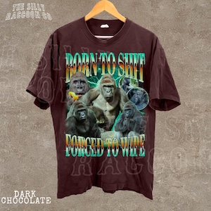 A t-shirt with a graphic design featuring a group of gorillas and the text "BORN TO SHIT FORCED TO WIPE" printed on it.