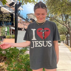 a girl in a t - shirt that says i love jesus