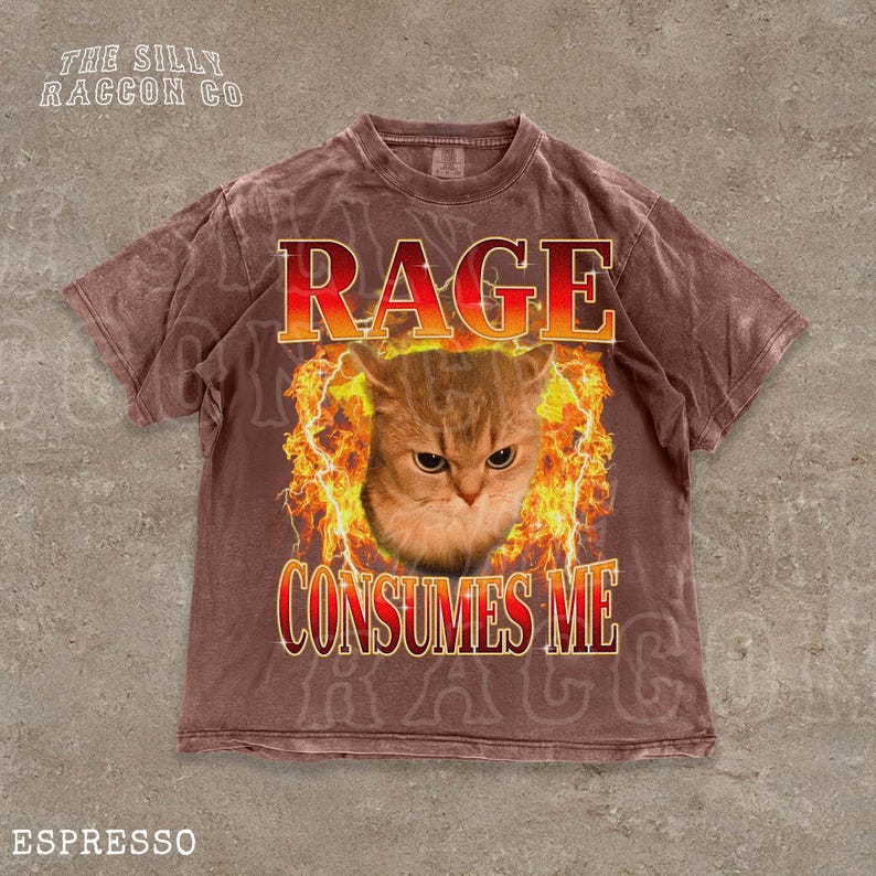 A t-shirt with a graphic design featuring a cat's face surrounded by flames, with the text "RAGE CONSUMES ME" prominently displayed.