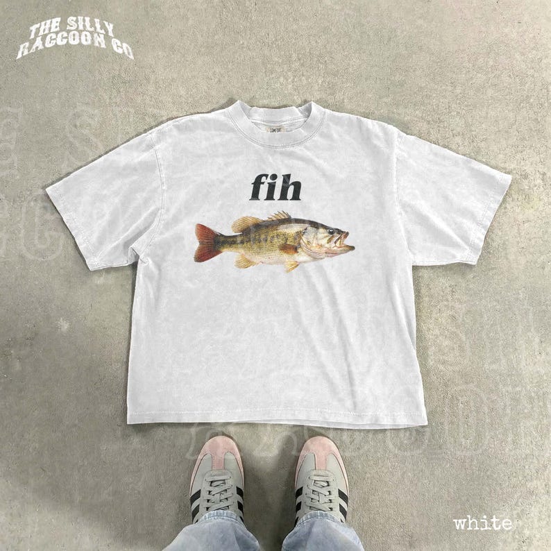 A white t-shirt with a fish graphic printed on it, along with a pair of white sneakers.