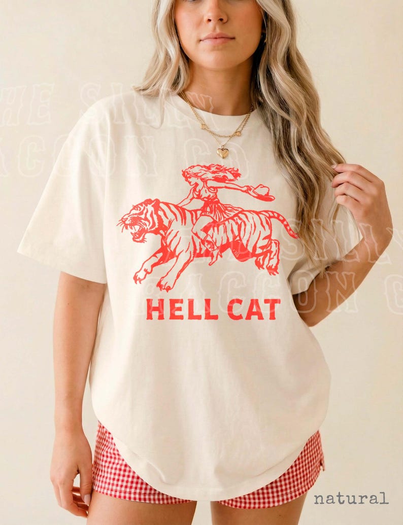 A woman wearing a white t-shirt with a graphic design of a tiger and the text "HELL CAT" printed on it.