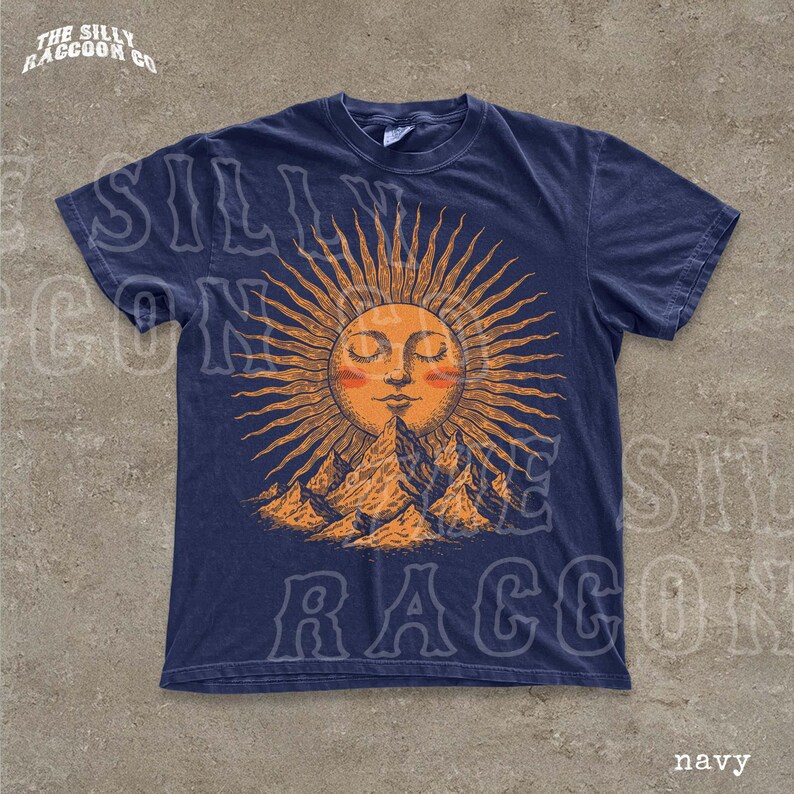 A navy blue t-shirt with a sun and mountain graphic printed on it.