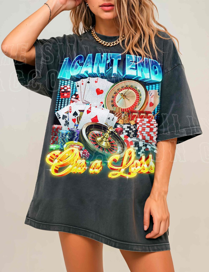 A woman wearing a black t-shirt with a graphic design featuring casino elements, including a roulette wheel, playing cards, and stacks of poker chips.