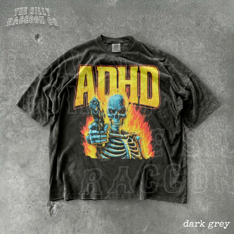 A black t-shirt with a graphic design featuring a skeleton holding a gun and flames behind it.