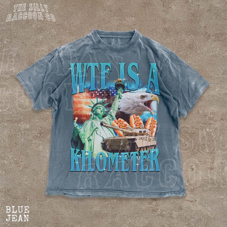 A t-shirt with a graphic design featuring the Statue of Liberty and an eagle, along with the text "WTF IS A KILOMETER" printed on it.