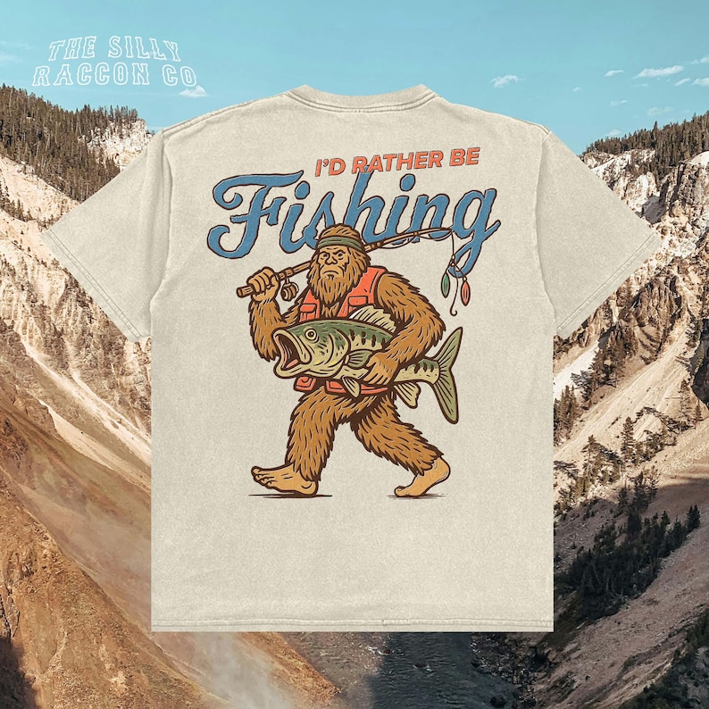 a t - shirt with a bigfoot holding a fish