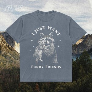a t - shirt with a picture of a raccoon hugging a wolf