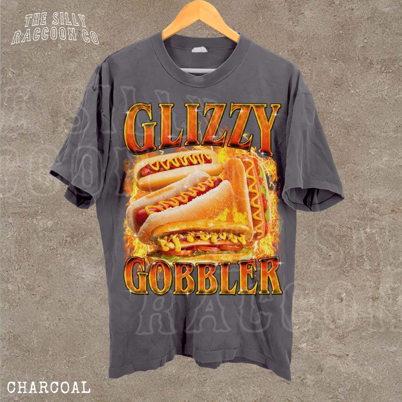 A gray t-shirt with a graphic design featuring a large hot dog surrounded by flames and the text "GLIZZY GOBBLER" prominently displayed.