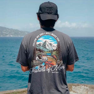 a man looking out at the ocean from a cliff