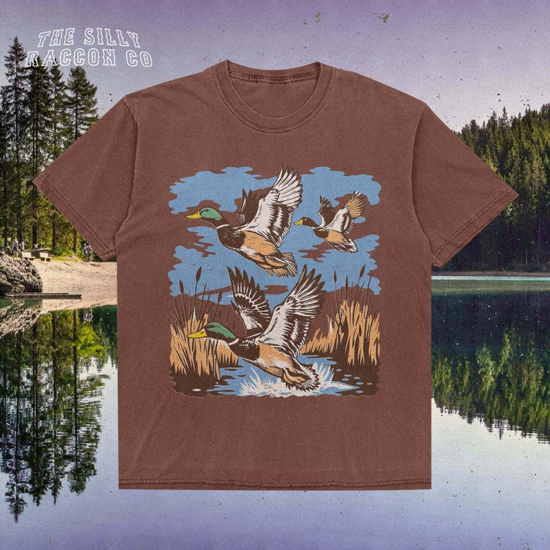 a brown shirt with ducks flying over a lake