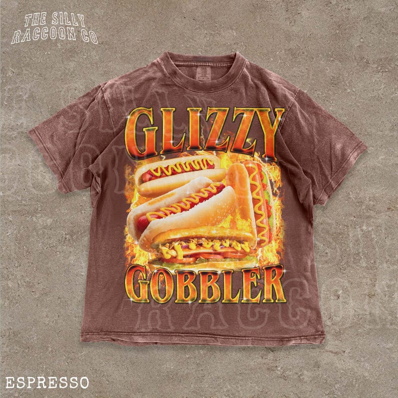 A brown t-shirt with a graphic design featuring two hot dogs on a flame background, along with the text "GLIZZY GOBBLER" and "ESPRESSO".