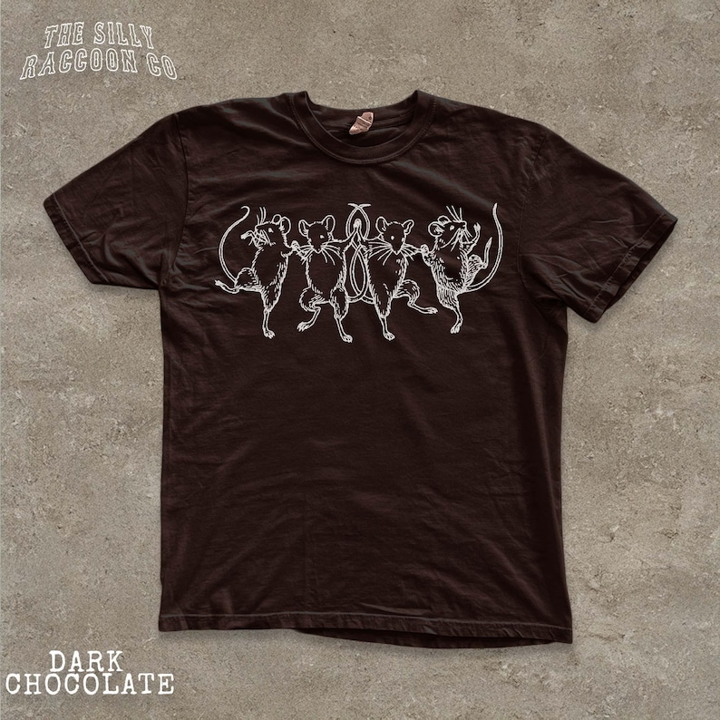 A dark brown t-shirt with a white graphic design depicting a group of cats.
