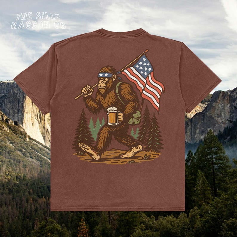 a t - shirt with a picture of a bigfoot holding a flag and a
