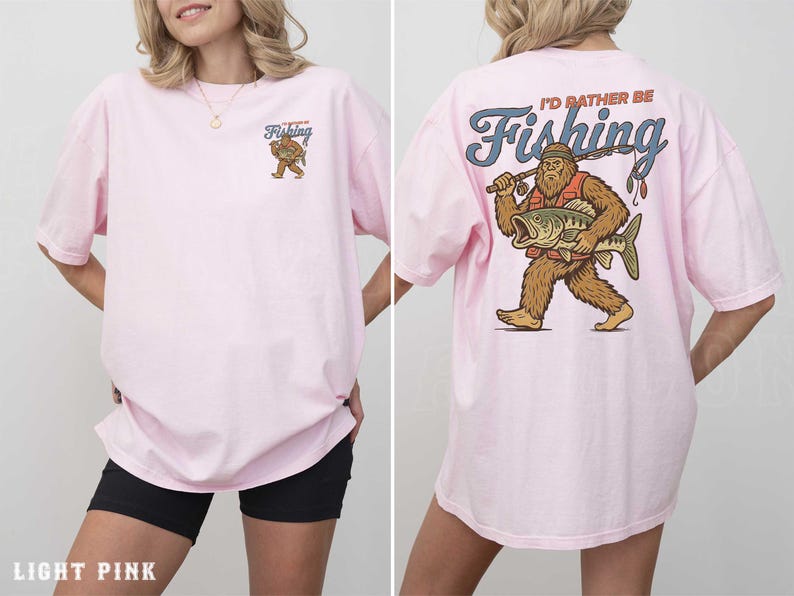 A woman wearing a pink t-shirt with a cartoon image of a giant fish and the text "I'd rather be fishing" printed on the back.