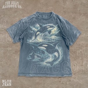 A blue t-shirt with a graphic design of two killer whales in the ocean.