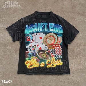 A black t-shirt with a graphic design featuring various casino-related elements, including playing cards, a roulette wheel, and stacks of poker chips. The text on the t-shirt reads "I CAN'T END ON A LESS THAN 500 CHARACTERS".