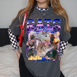 A person wearing a gray t-shirt with a graphic design featuring a group of mice and cheese.