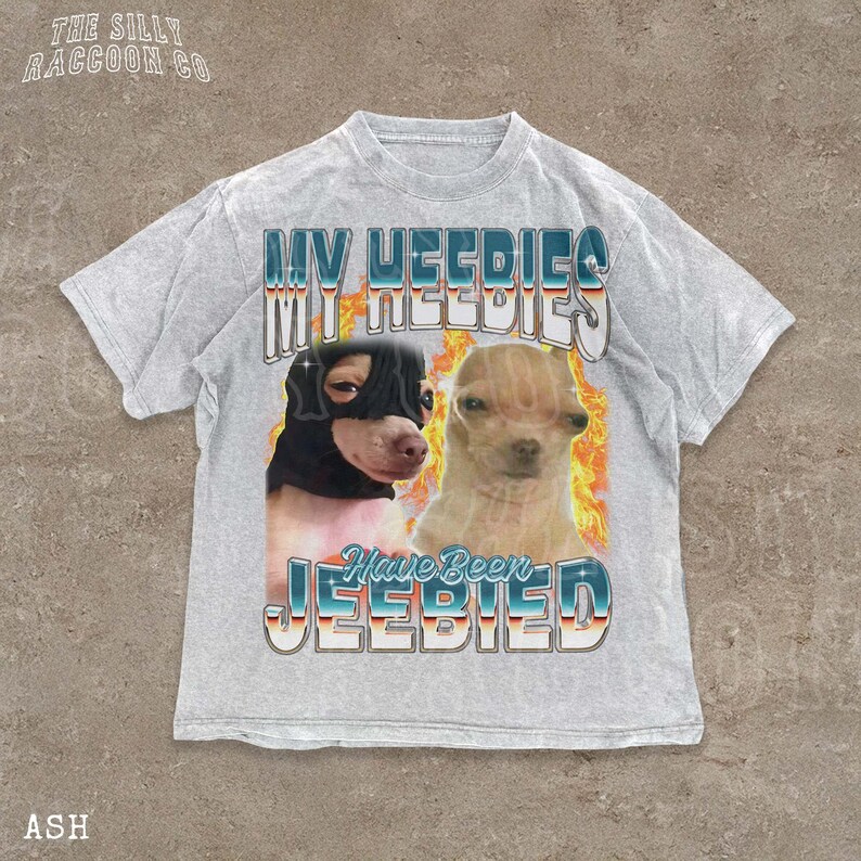 A t-shirt with a graphic design featuring two dogs, one black and one tan, with flames and text overlaying the image.