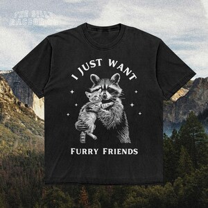 a black t - shirt with a picture of a raccoon hugging another ra