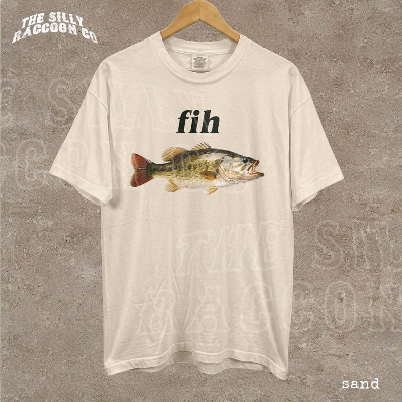 A white t-shirt with a printed image of a fish and the word "fih" printed on it.