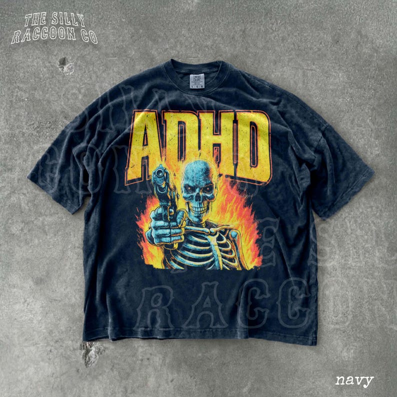 A navy blue t-shirt with a graphic design depicting a skeleton holding a gun and surrounded by flames.