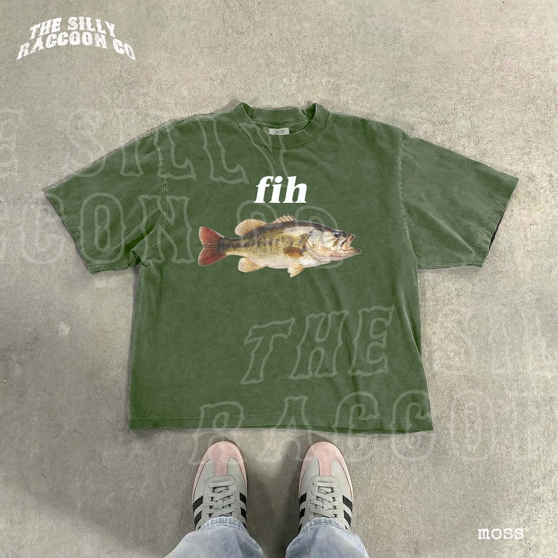 A pair of green t-shirts with a fish graphic and the word 'fih' printed on them, along with a pair of white sneakers.