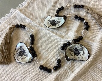 Guirnalda de conchas de ostra con mensajes inspiradores de abejas