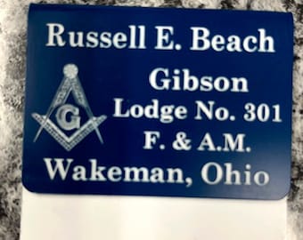 May include: A blue and white name badge with the text "Russell E. Beach Gibson Lodge No. 301 F. & A.M. Wakeman, Ohio." The badge features a Masonic symbol and a white rectangular section.