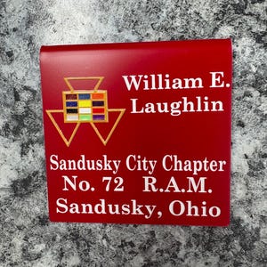 May include: A red rectangular plaque with white text and a gold emblem. The text reads "William E. Laughlin" and "Sandusky City Chapter No. 72 R.A.M. Sandusky, Ohio."