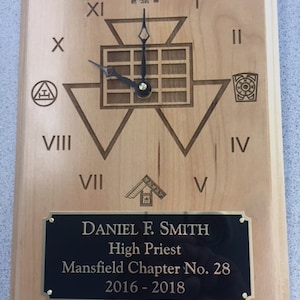 May include: A wooden plaque with a Masonic clock face and a brass plaque with the text "DANIEL F. SMITH High Priest Mansfield Chapter No. 28 2016-2018".