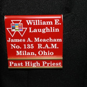 May include: Red and gold name tag with white text. The text reads "William E. Laughlin, James A. Meacham, No. 135 R.A.M., Milan, Ohio, Past High Priest".