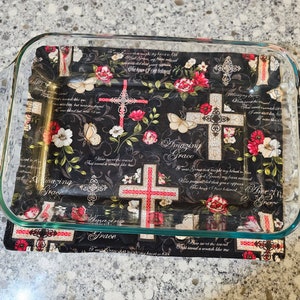 Könnte beinhalten: Eine Glas-Backform mit einer schwarzen und weißen Stoffauskleidung mit einem Kreuzmuster, roten Rosen und dem Text "Amazing Grace".