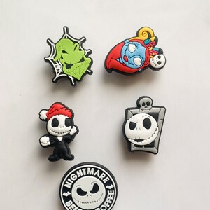 Puede incluir: Una colecci&oacute;n de coloridos dijes para zapatos con personajes de "Pesadilla antes de Navidad". Incluye a Oogie Boogie, Sally, Jack Skellington y un dije con el texto "Nightmare Before Coffee."