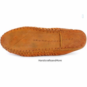 May include: The bottom of a brown leather slipper with a stitched edge.