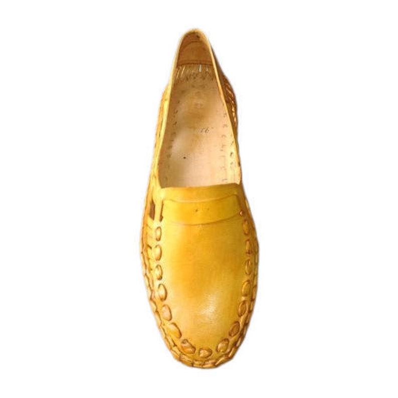 May include: A pair of yellow leather slip-on shoes with a woven design.