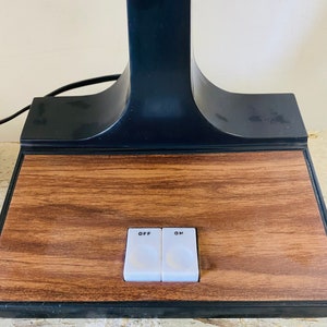 May include: A black table lamp with a wooden base and two toggle switches labeled "OFF" and "ON".