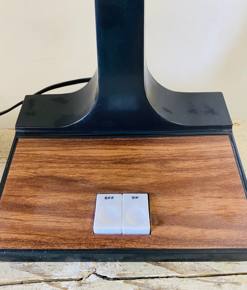 May include: A black table lamp with a wooden base and two toggle switches labeled "OFF" and "ON".