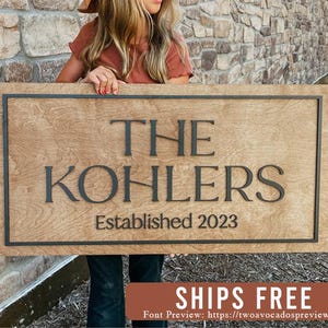 May include: A wooden sign with the text "The Kohlers Established 2023" in black lettering. The sign is brown and has a black frame.