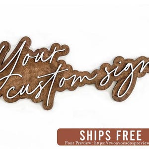 May include: A wooden sign with the text "Your custom sign" written in white script font.