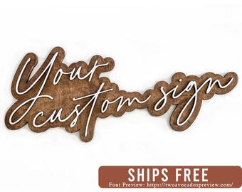 May include: A wooden sign with the text "Your custom sign" written in white script font.