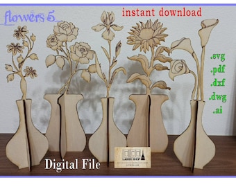 Peut inclure: Cinq fichiers de découpe numériques de fleurs dans des vases. Les fichiers sont disponibles aux formats SVG, PDF, DXF, DWG et AI. L'image montre une découpe en bois des fleurs et des vases.