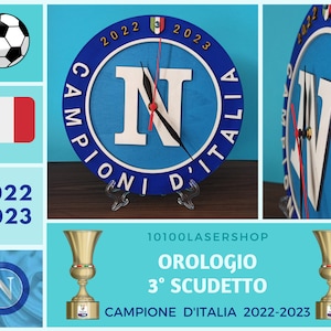 May include: A blue and white wooden clock with the letter "N" in the center, surrounded by the words "Campioni D'Italia" and the years "2022 2023". The clock also features a soccer ball and the Italian flag.