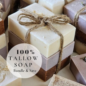 May include: Handmade tallow soap bars in white, lavender, and brown, tied with twine. The image shows multiple stacks of soap. Text on the image reads "100% Tallow Soap Bundle & Save."