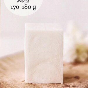 May include: A rectangular, off-white tallow soap bar. The soap is displayed on a wooden surface. Text on the image reads "TALLOW SOAP BAR" and "Weight: 170-180 g".