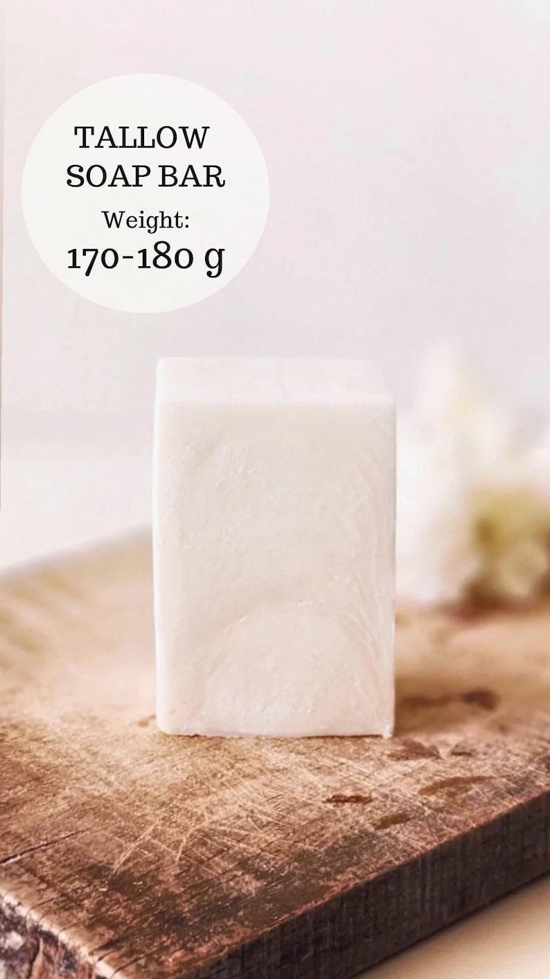 May include: A rectangular, off-white tallow soap bar. The soap is displayed on a wooden surface. Text on the image reads "TALLOW SOAP BAR" and "Weight: 170-180 g".