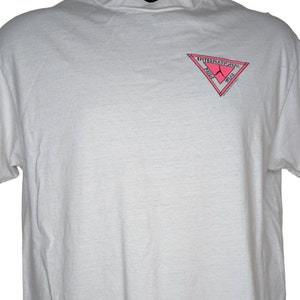 Könnte beinhalten: Weißes T-Shirt mit einem rosa Dreieckslogo, auf dem "International Pride Week" steht.