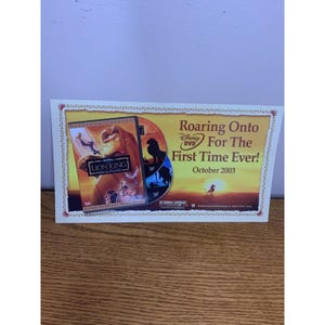 May include: A rectangular promotional card for The Lion King Special Edition Disney DVD. The card features the movie cover, two discs, and the text Roaring Onto Disney DVD For The First Time Ever! October 2003 against a sunset savanna background.